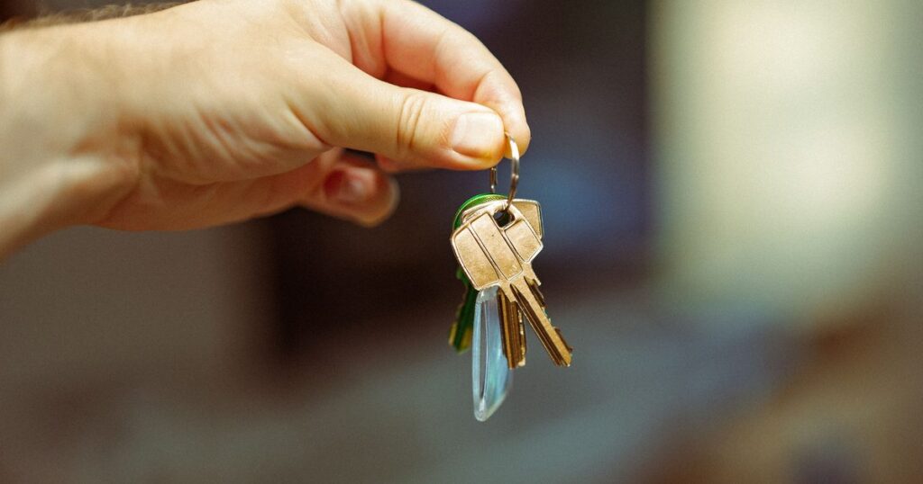 Hand holding a set of apartment keys at handover