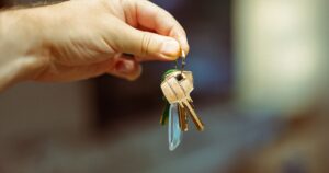 Hand holding a set of apartment keys at handover
