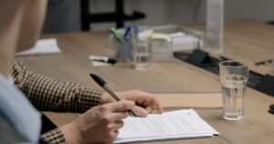 Signing a document at a desk, the written landlord consent arbitrage depends on