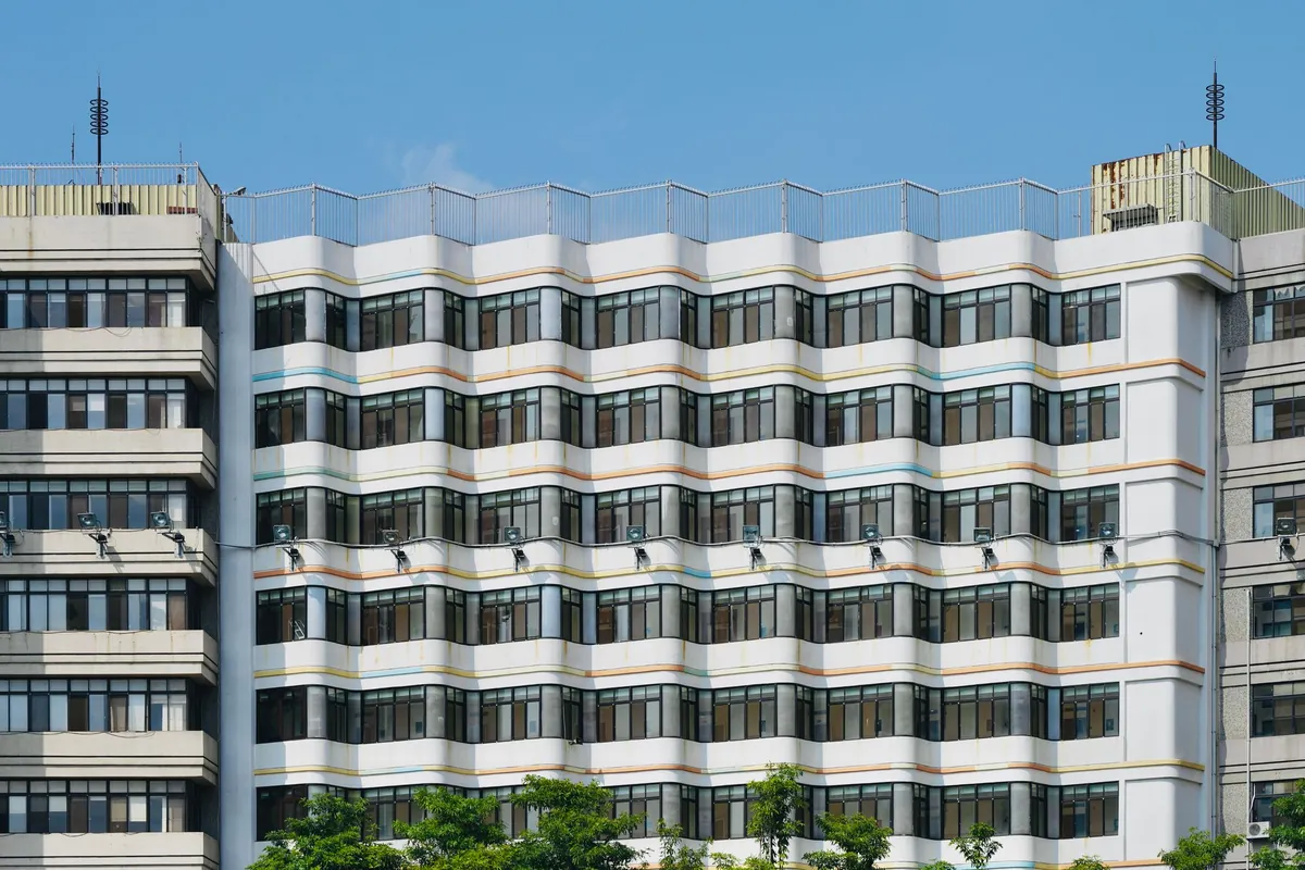 The curved facade of a contemporary apartment building, floor after floor of windows