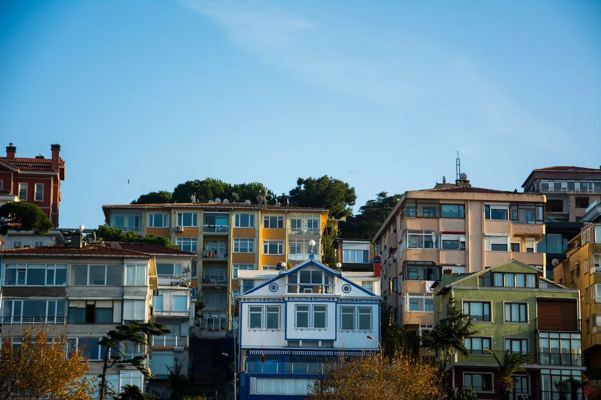 A hillside of densely built, brightly painted residential buildings under a clear sky
