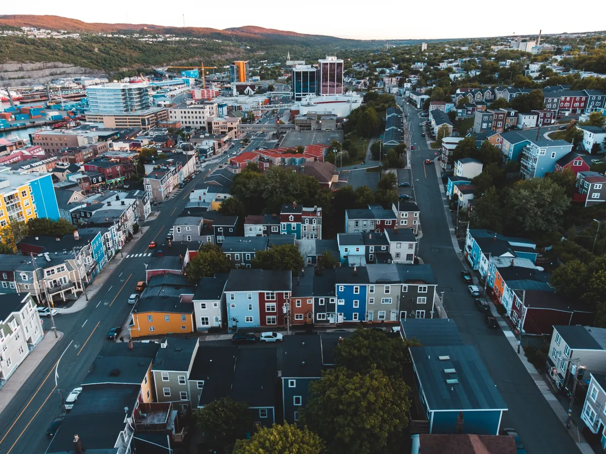 An aerial view of a colourful hillside town beside the water