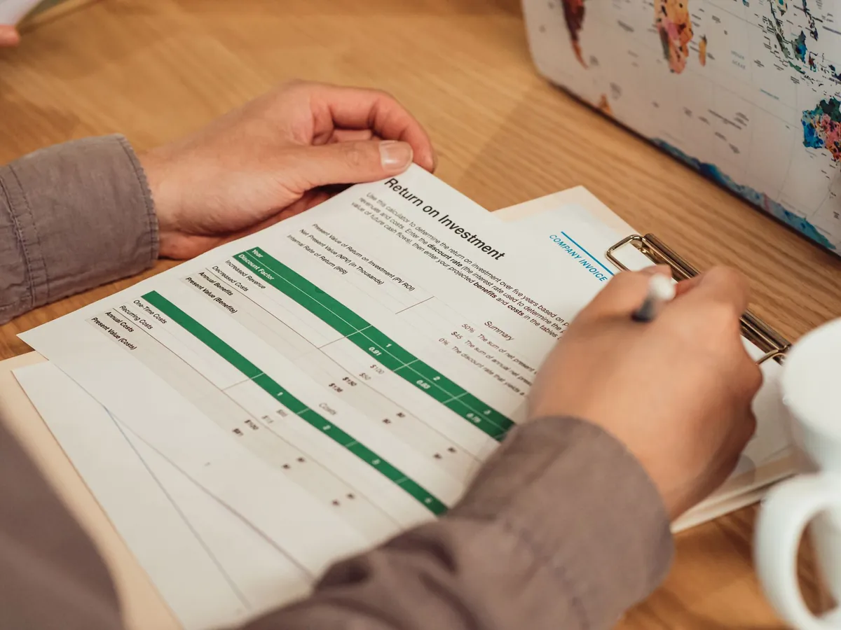 A person reading a printed report and marking it with a pen
