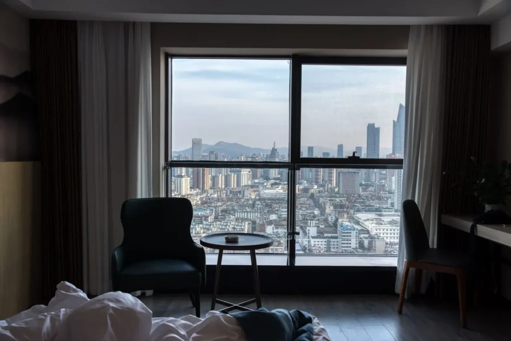 A hotel room window looking out over a city skyline