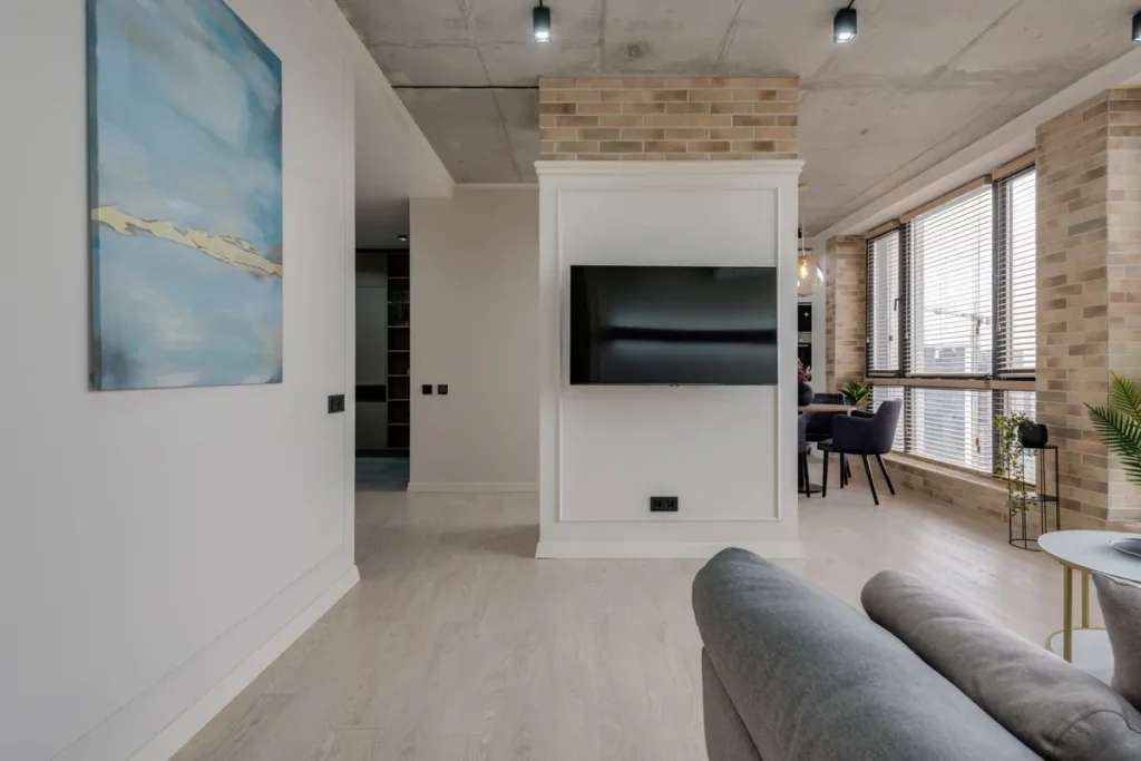 A modern living room reset and ready, with a sofa, a television and a low table