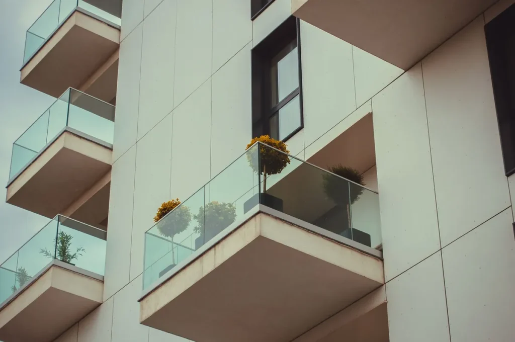 Glass balconies with potted plants on a modern apartment building