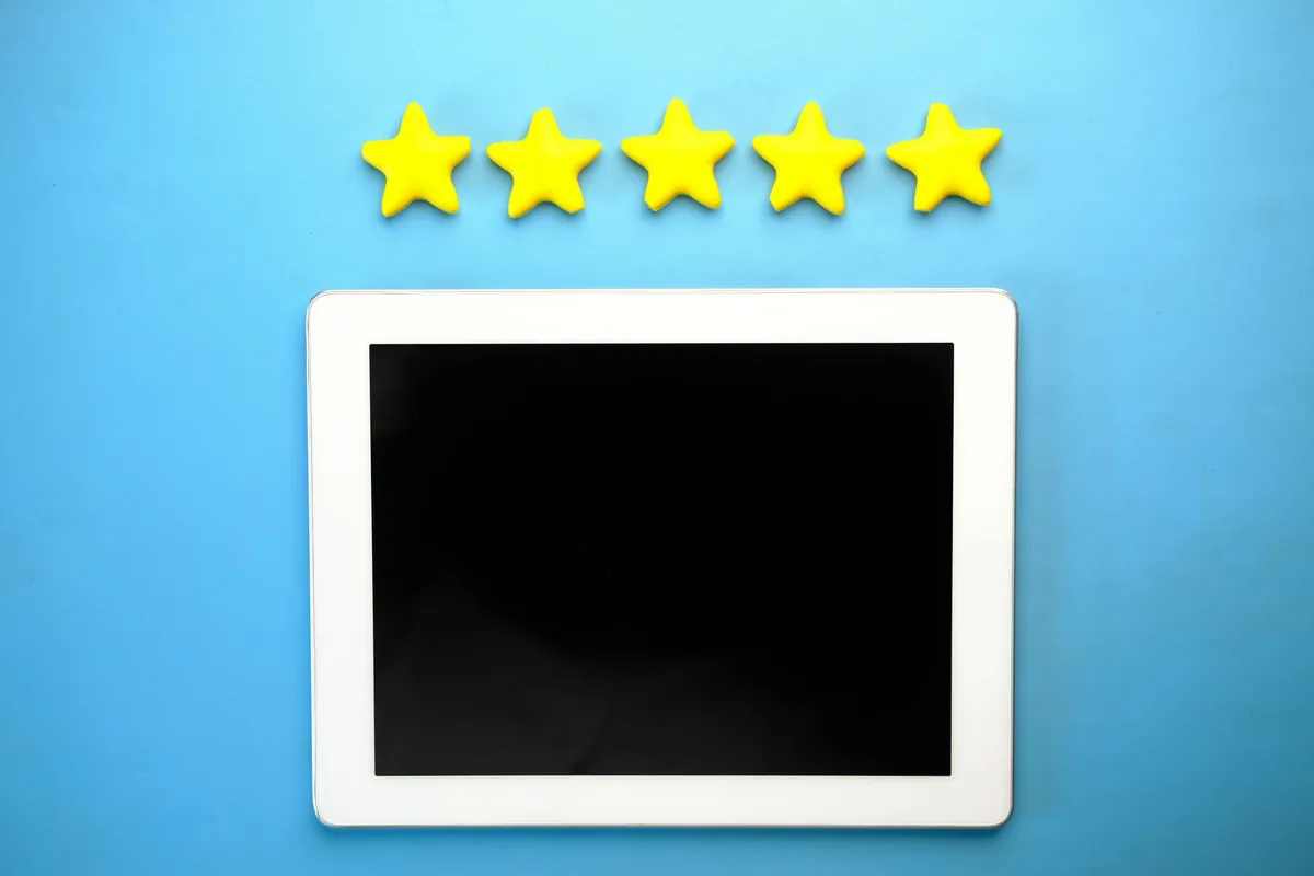Five yellow stars above a tablet with a blank screen on a blue background