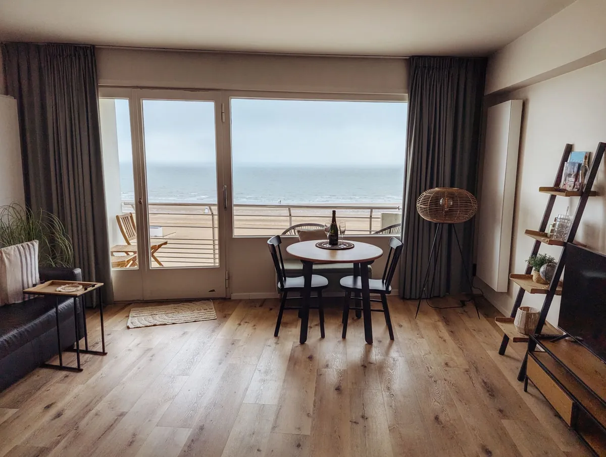 A cozy living room in a beachfront apartment with an ocean view through the window