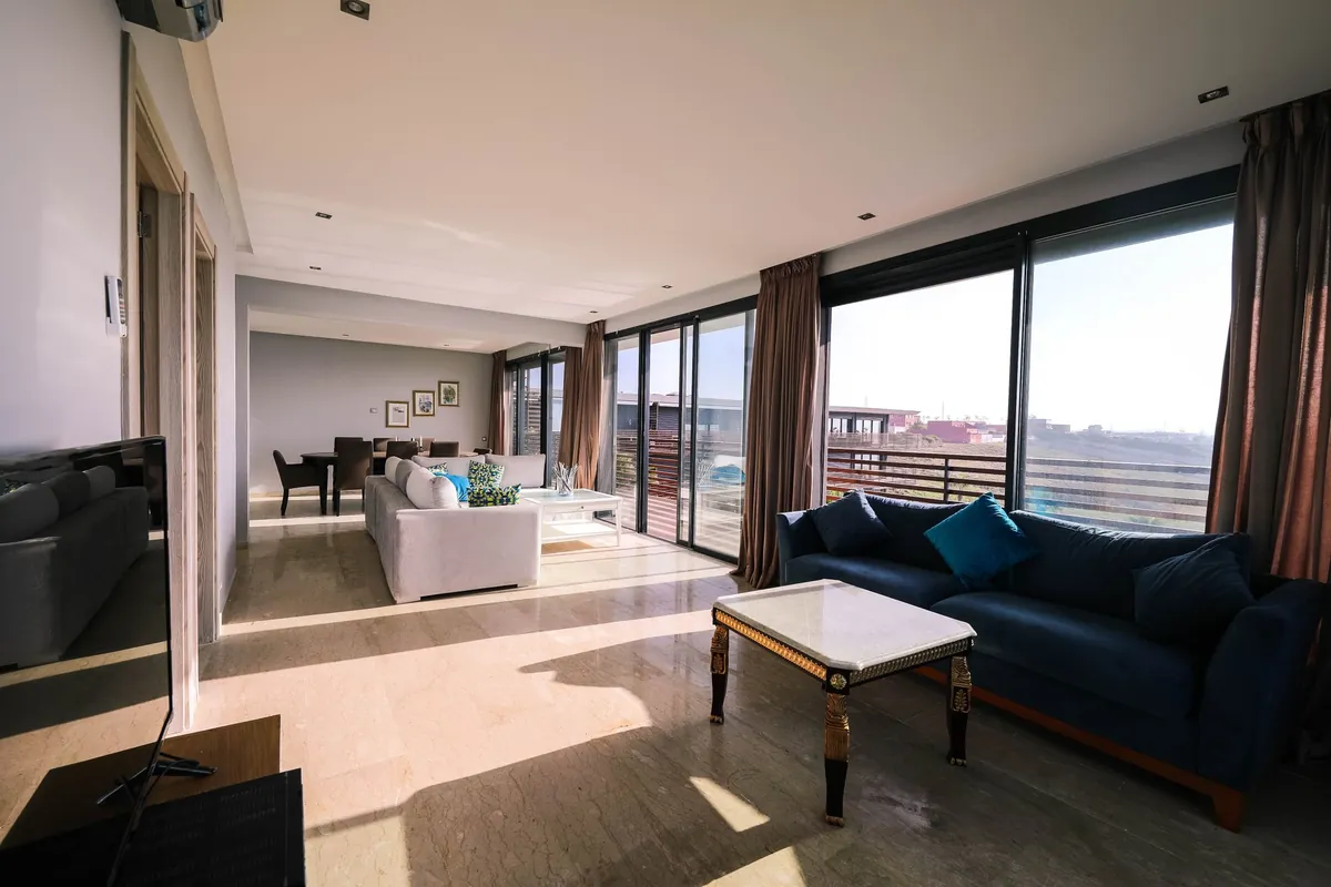 A bright contemporary living room with a sofa and large windows