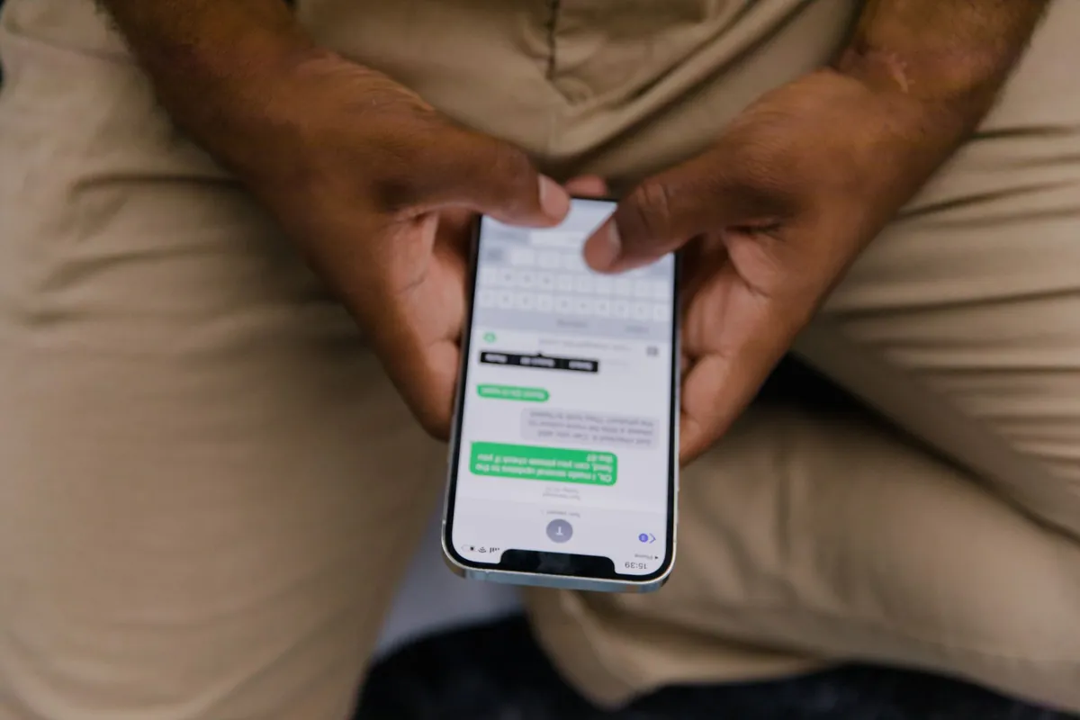 Close-up of a person holding a phone showing an open message thread