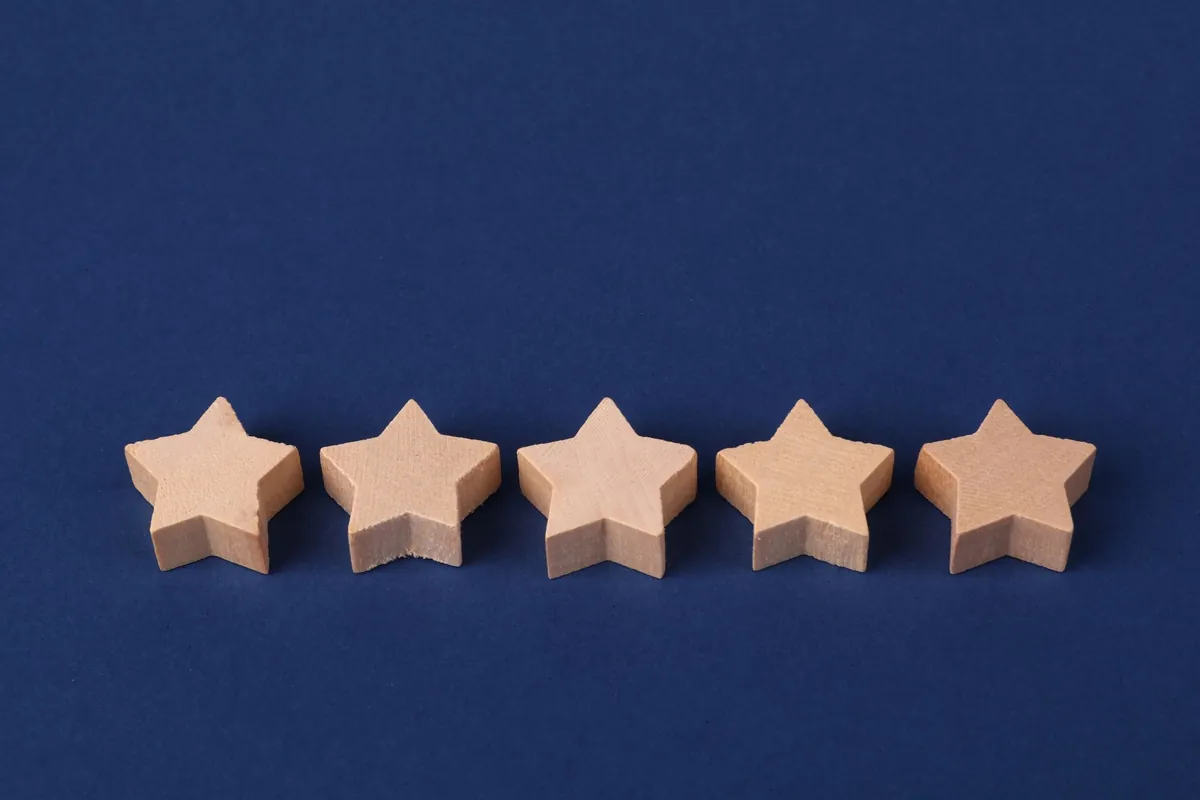 Five wooden stars arranged in a row on a deep blue background