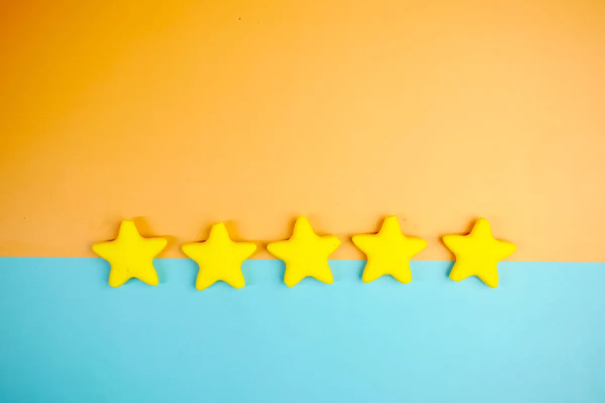 Five yellow stars laid in a row across an orange and blue background