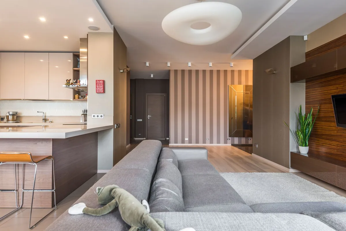 A spacious, minimally furnished living room with daylight across the floor