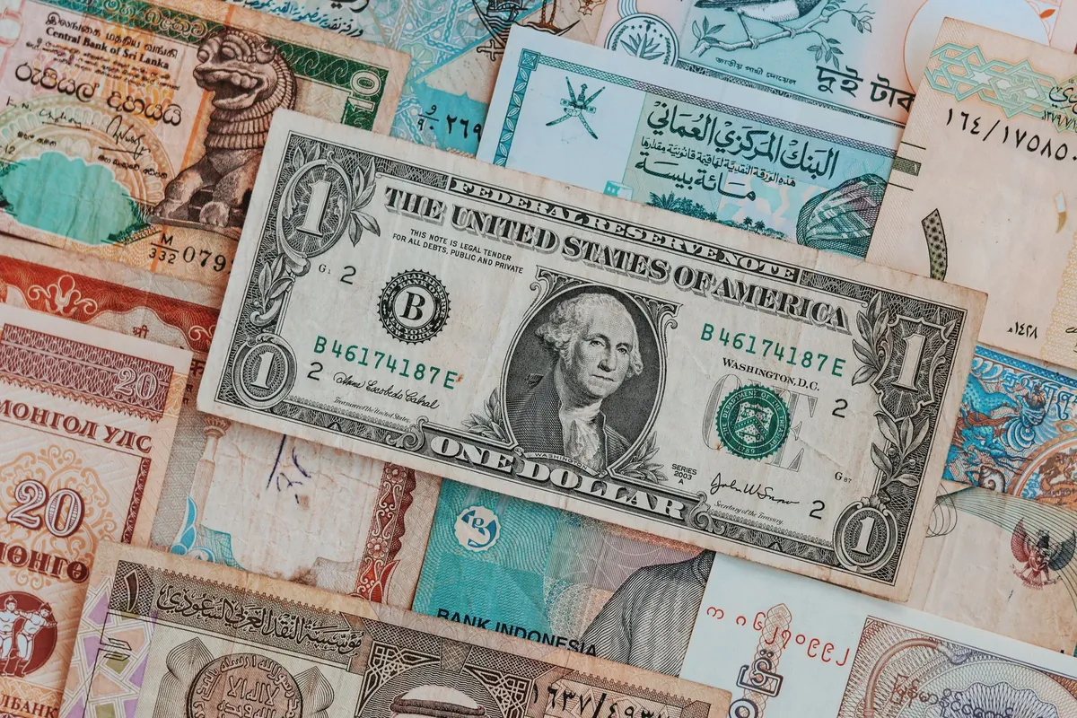 A one-dollar note lying on top of banknotes from several other countries