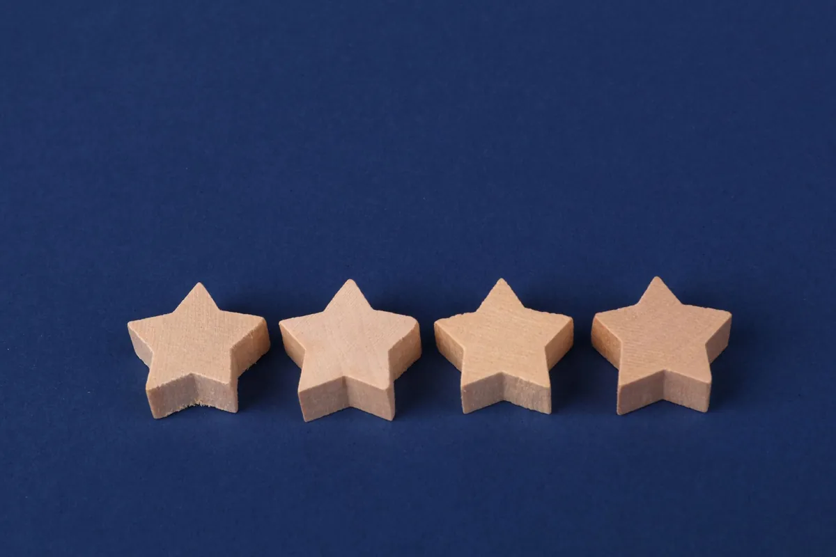 Four wooden star shapes arranged on a plain navy background