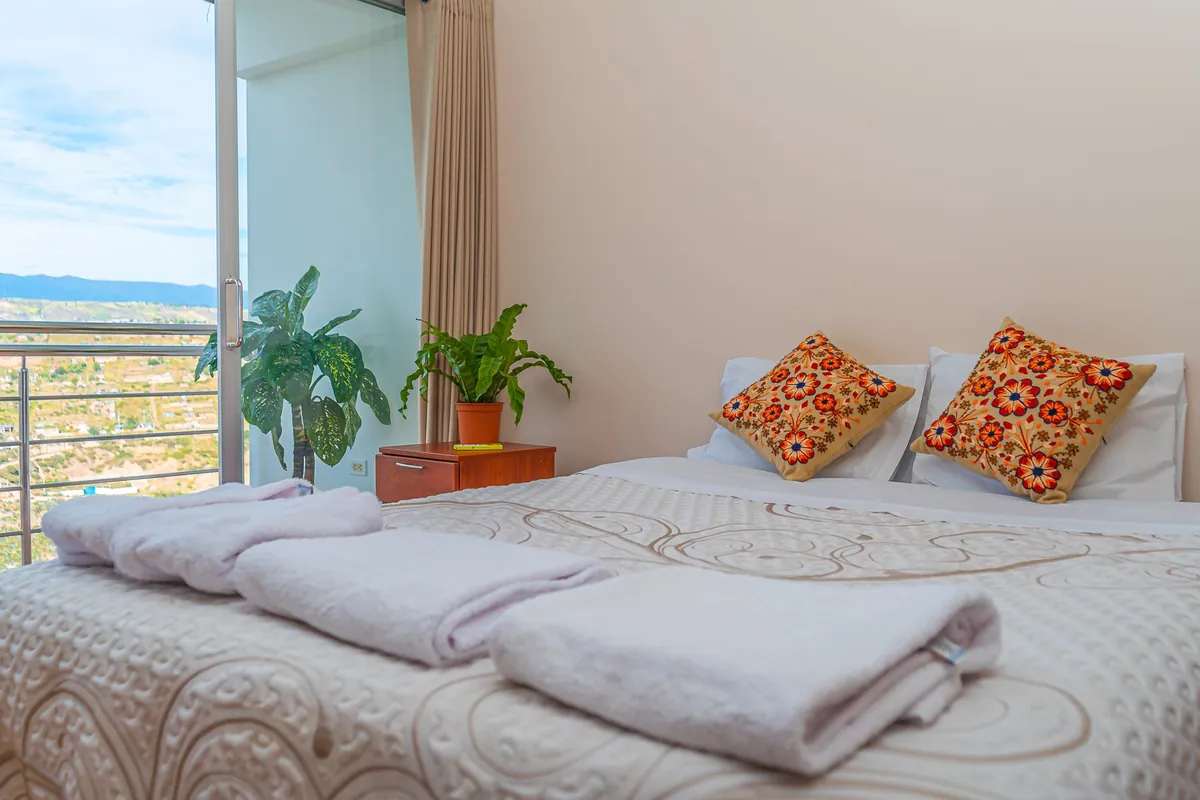 Inviting bedroom with decorative pillows and a scenic view through the window