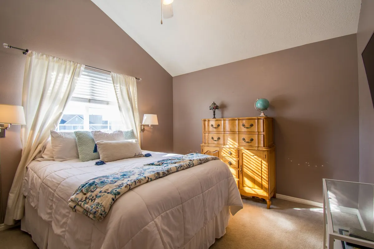 Bright bedroom with neutral tones, elegant decor, and a neatly made bed.