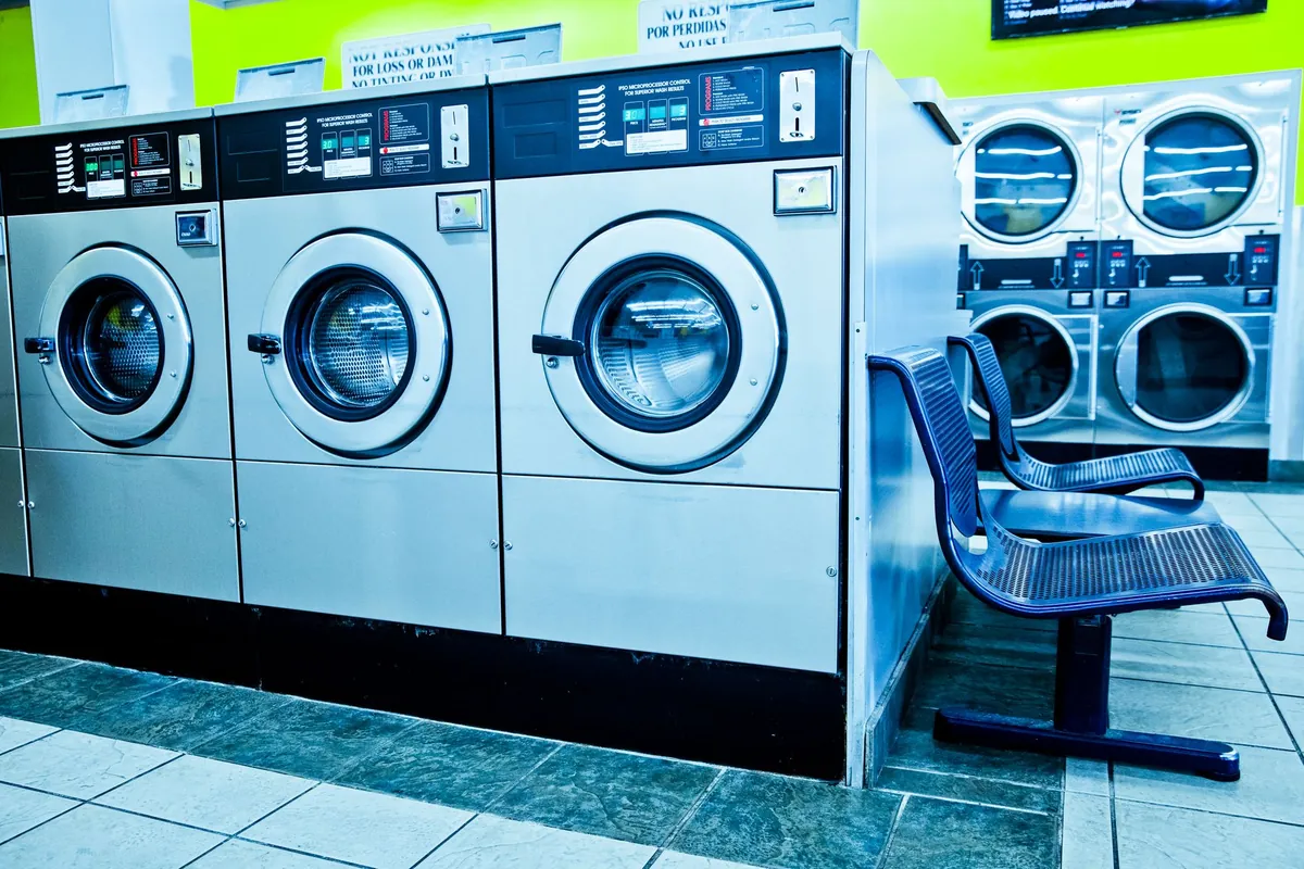 Interior of a modern laundromat with rows of self-service washing machines