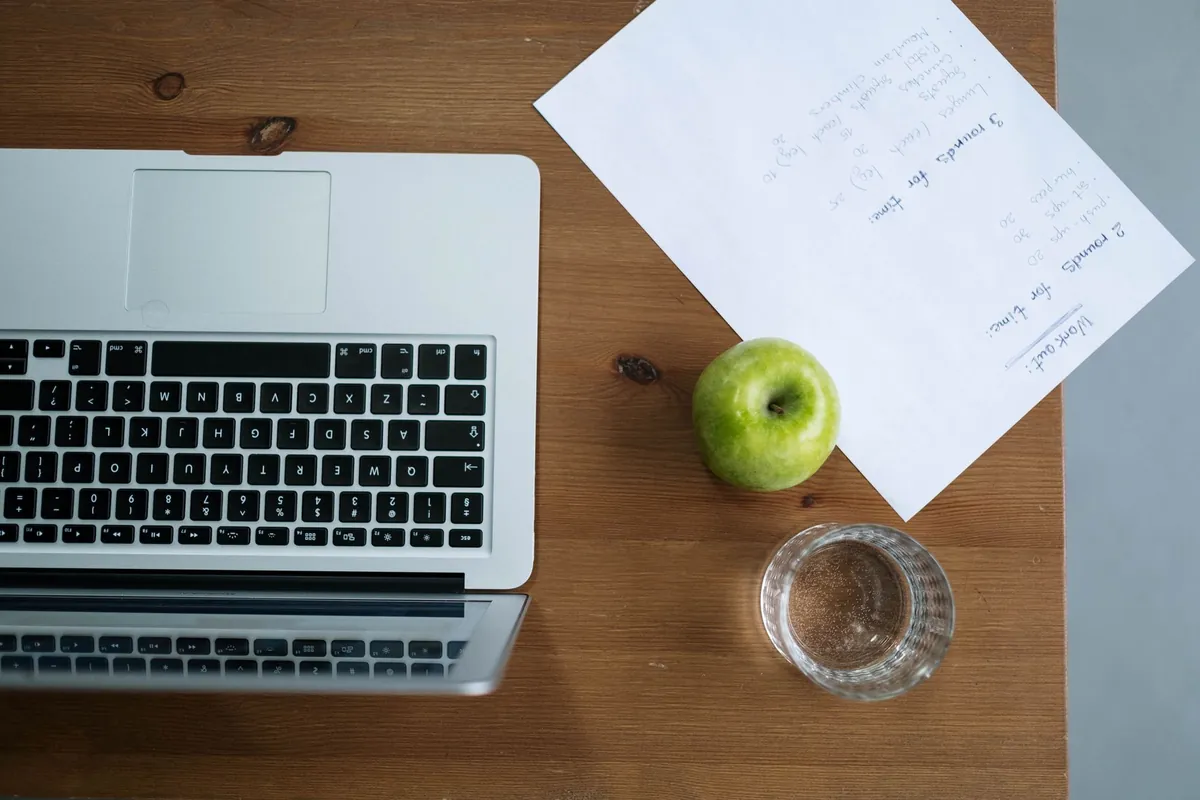 Laptop, handwritten notes, and paper on a home workspace