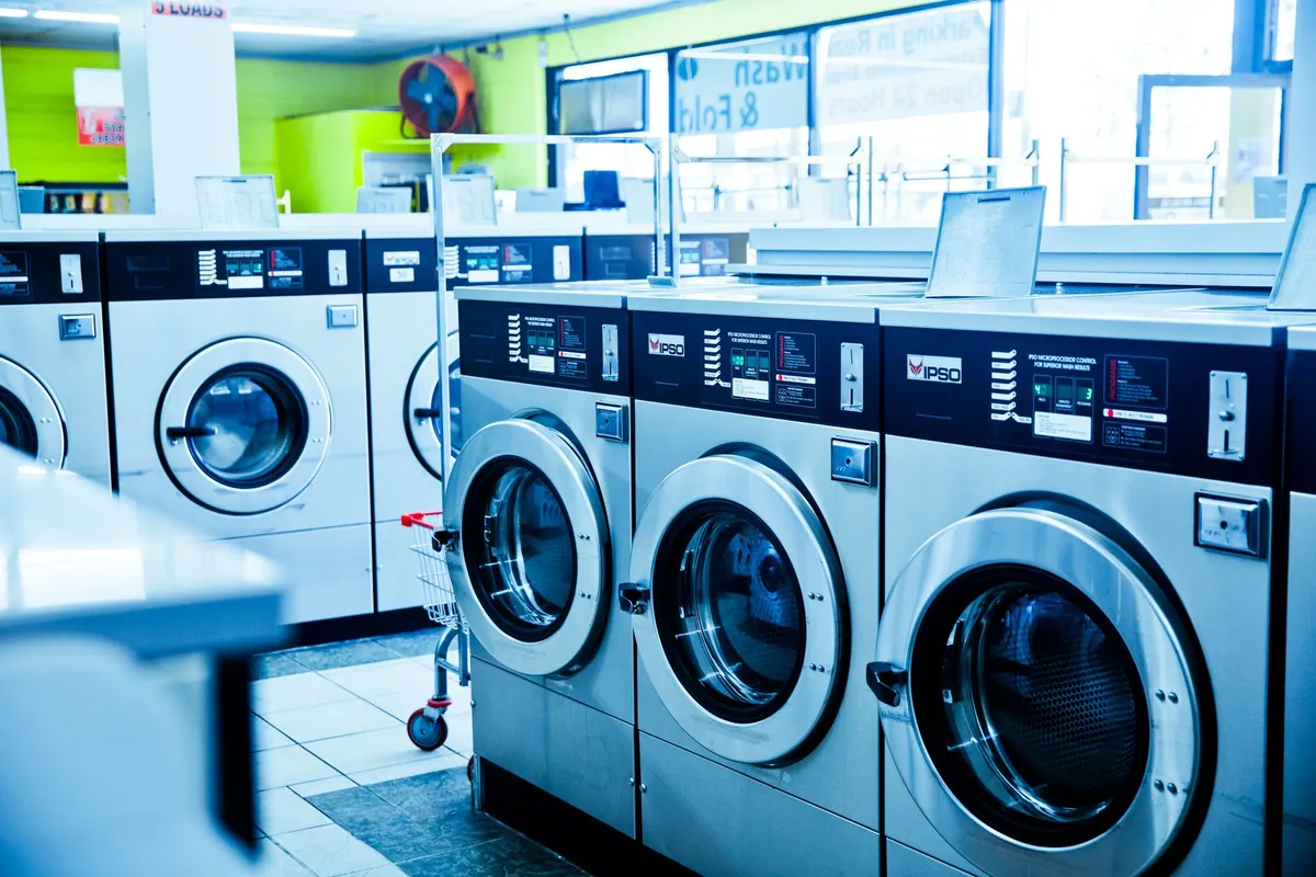 Row of industrial washing machines inside a modern laundromat