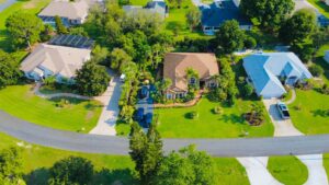 Aerial view of a green Florida residential neighborhood with houses and tree-lined streets.