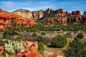 Red rock formations and green trees under a clear sky in Sedona, Arizona