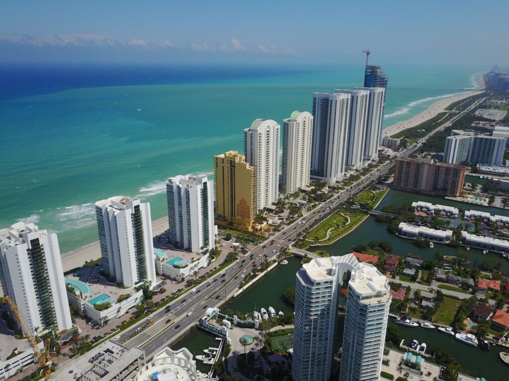 Aerial view of beachfront high-rise buildings along a sunny coastline