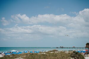 Beach umbrellas on white sand overlooking a calm ocean under a clear sky