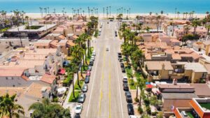 Aerial view of a beachside neighborhood with houses and a sandy coastline along the ocean.