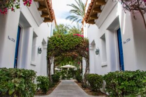 Resort pathway lined with blue doors and lush green landscaping in a desert community