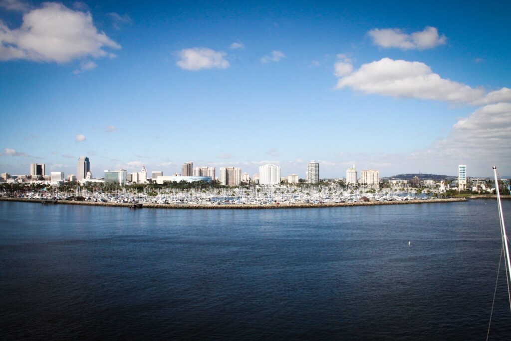 Long Beach skyline and marina seen across blue water under a clear blue sky