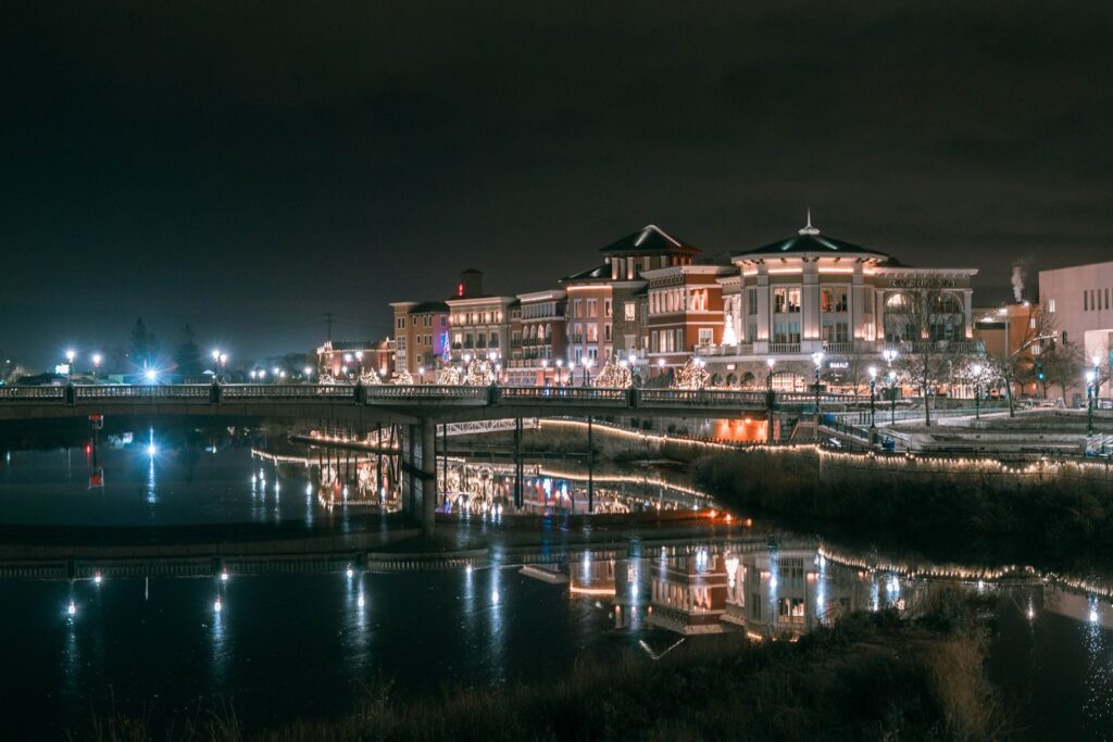 Napa River at night reflecting lights of downtown buildings and a bridge.