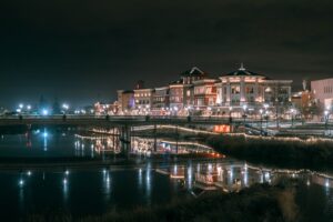 Napa River at night reflecting lights of downtown buildings and a bridge.