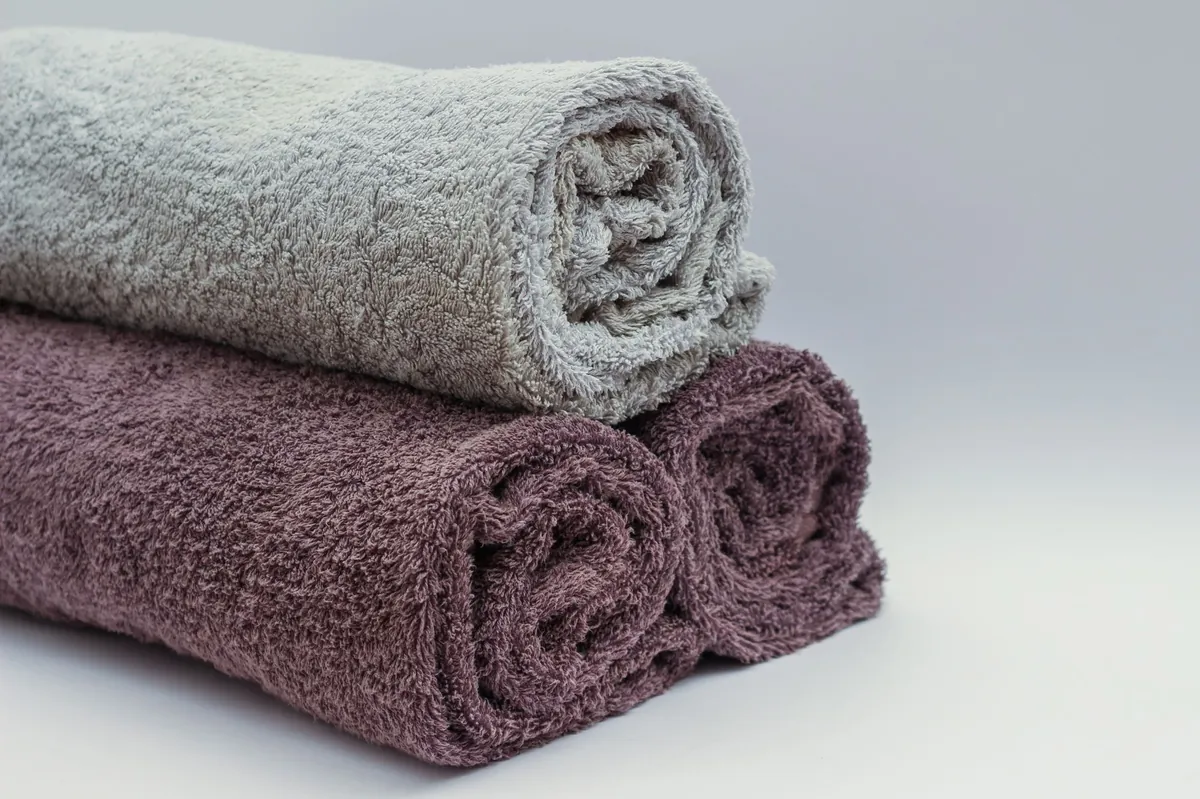 Close-up of rolled grey and mauve bath towels