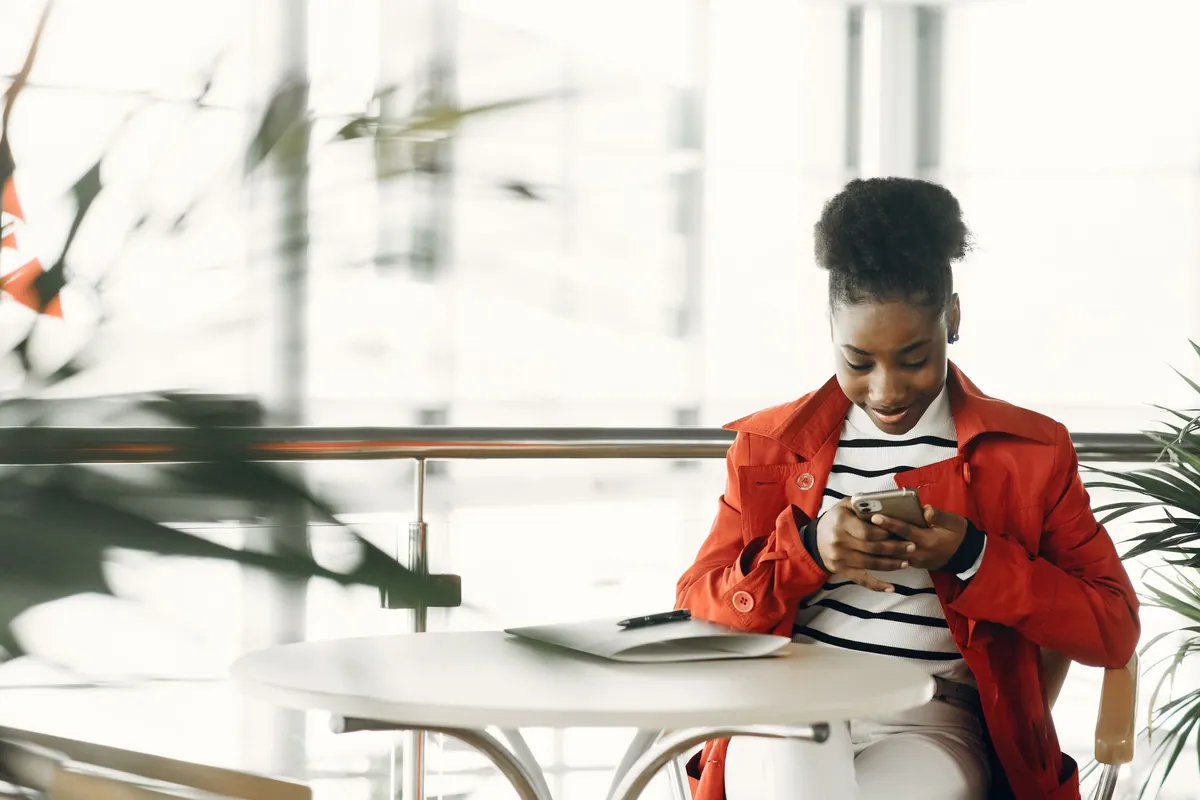 Woman sitting in a cozy café looking at her smartphone